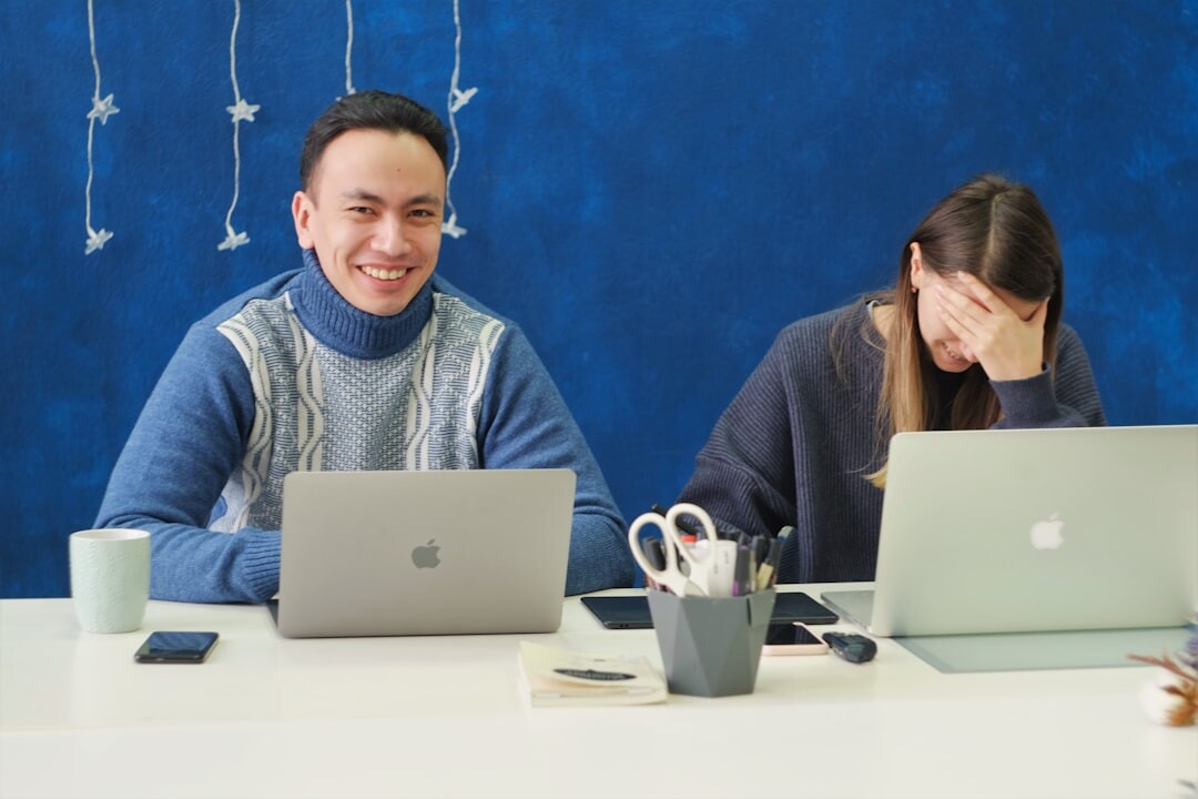 Journalists working on laptops in a busy newsroom