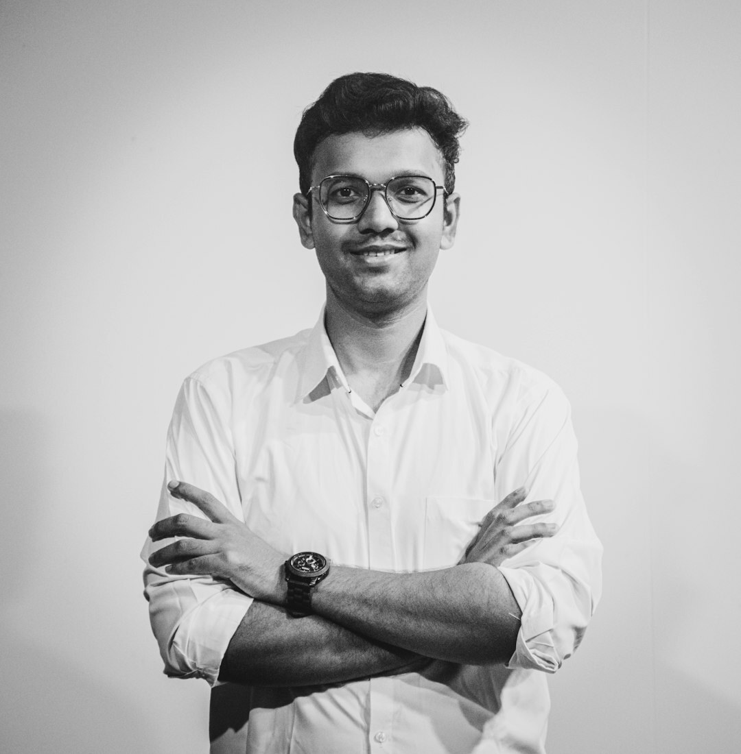 Studio portrait of a man with glasses smiling